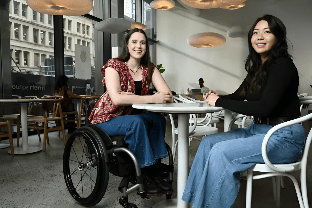 Community member using a wheelchair with a companion nearby
